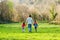 Father with children walking out of town through the countryside. Family rural travel