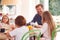 Father With Children Wearing Pyjamas Sitting Around Table Enjoying Pancake Breakfast Together