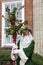 Father Christmas robed in green, masked and carrying holly branc