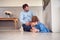 Father Comforting Unhappy Daughter Sitting On Floor Holding Teddy Bear