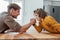 Father competing in arm wrestling with teen son, family spending time together