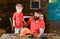 Father and cute blond son in workshop. Daddy holding his boy behind the table with various tools. Kid looking at