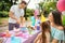 Father cutting tasty cake at birthday party outdoors