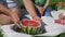 Father Cutting Watermelon to Children Outdoors