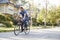 Father Cycling Along Street With Daughter In Child Seat