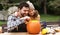 Father and daughter carving pumpkin for halloween in backyard