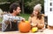 Father and daughter carving pumpkin for halloween in backyard