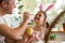 A father and daughter celebrating Easter, painting eggs with brush.
