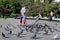 Father and daughter feed pigeons in the park `Lilac garden` in Moscow