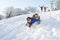 Father And Daughter Having Fun Sledging Down Hill