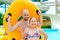 Father and daughter having fun on water slides in aqua park