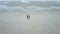 Father and daughter holding hands walking on the beach