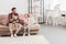 father and daughter holding teddy bears sitting on couch and looking