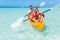 Father and daughter kayaking at tropical ocean