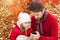 Father and daughter looking at the mobile phone in an autumn park