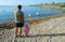 Father and daughter looking at swans on the beach