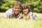 Father and daughter lying outdoors with flowers