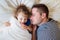 Father and daughter lying in parents bed, sleeping, smiling