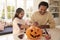 Father And Daughter Making Halloween Decorations At Home