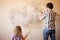 Father and daughter repairing wall, holding putty knife