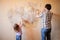 Father and daughter repairing wall, holding putty knife