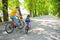 Father and daughter ride bikes in the Park on a Sunny day. Dad teaches the child Cycling