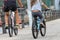 Father and daughter ride bikes, rear view