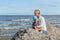 Father with daughter on sea and sky backgrounds. Man and baby are point out forward. Parent and child together at summer. Family,