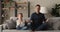 Father and daughter seated cross-legged meditating together at home