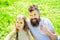 Father and daughter sits on grass at grassplot, green background. Superstar concept. Family spend leisure outdoors