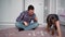 Father and daughter are sitting on the floor in a bright children`s room and playing a board game find a match