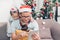 Father and daughter sitting on sofa and select christmas presen