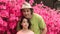Father and daughter standing in front of pink azalea flowers in tshirt on hot spring day