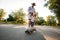 Father with daughter stands on skateboard on the road in the park