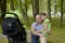 Father and daughter walk with a stroller in a forest Park in the spring.