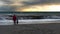 Father and daughter watching the waves reaching the beach as the swell from hurricane Eplsilon reaches the Cornish coastline