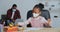 Father and daughter wear medical face masks at home, girl draws while dad works on laptop, afro american man teacher