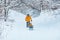 father with daughter in yellow winter coats sliding snowed hill