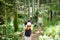 Father and daughters following a footpath around La Verna Sanctuary, Chiusi della Verna, in Casentino secular forest, one of the