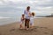 Father with daughters walking barefoot along the beach holding hands. Family relation. Vacation in Asia. Summer holidays. Happy