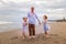 Father with daughters walking barefoot along the beach holding hands. Family relation. Vacation in Asia. Summer holidays. Happy