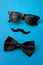 Father day and male hipster fashion concept with minimalist image of a pair of square sunglasses, black bowtie and a fake