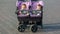 Father drives a baby carriage with two twin daughters,