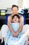 Father drying off on blue lounger with disabled son off side of