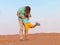 Father embraces the little son on a travel on the boundless desert. Orange sand,