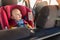 Father fasten his baby in car seat