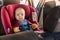 Father fasten his baby in car seat