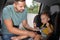 Father fastening his son with car safety belt in child seat