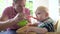 Father Feeding Baby Boy In High Chair