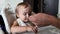 A father feeds his little daughter soup from a spoon. Close-up